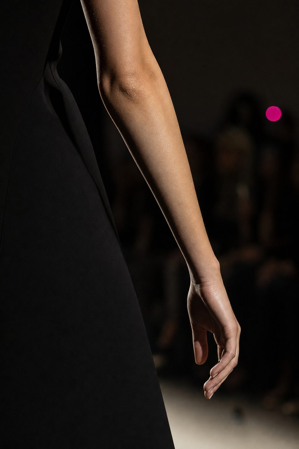 Model's arm while walking the runway: relaxed, swinging from the shoulder, loose fingers