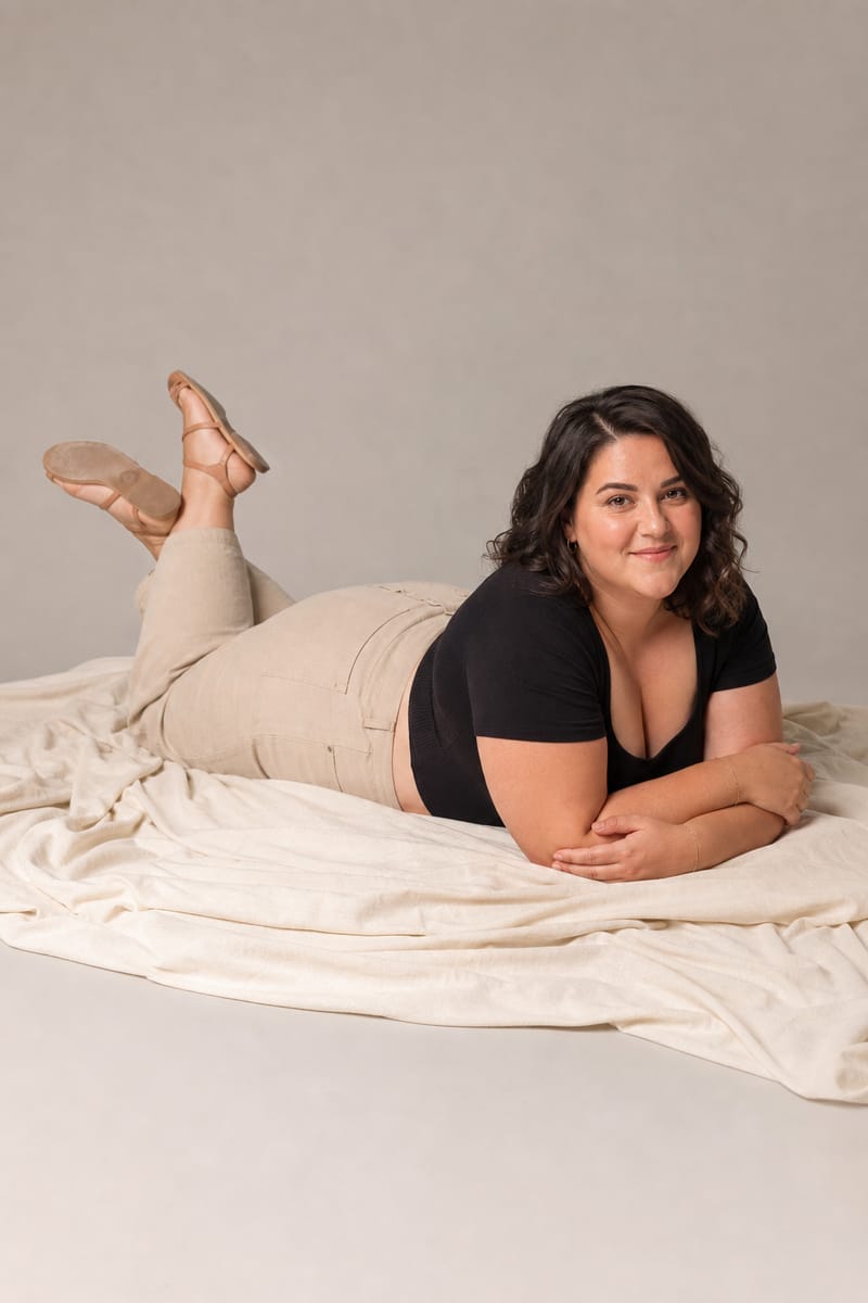 Plus size model lying on her stomach propped on her elbows