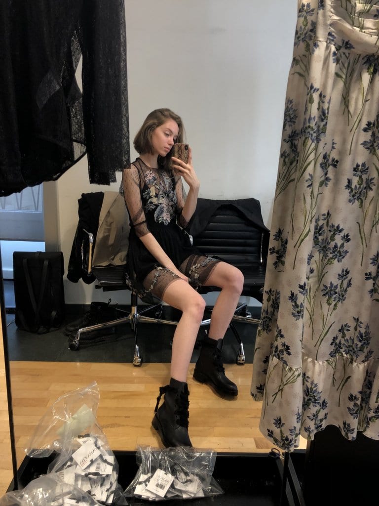The model photographs a fitted look in the mirror